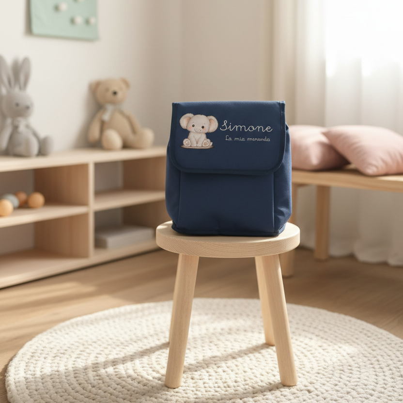 zainetto blu con personalizzazione sopra uno sgabello in una cameretta nordica
